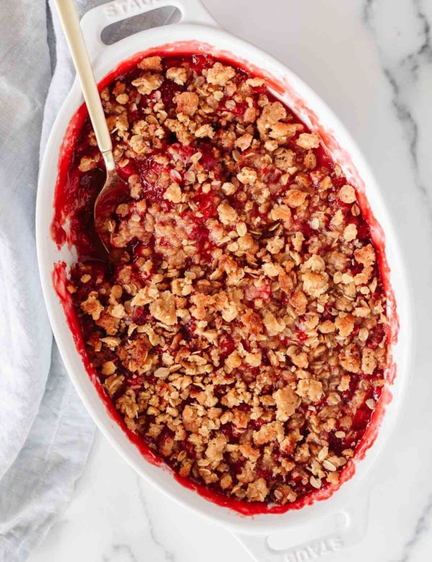 A strawberry crumble in a white oval baking dish