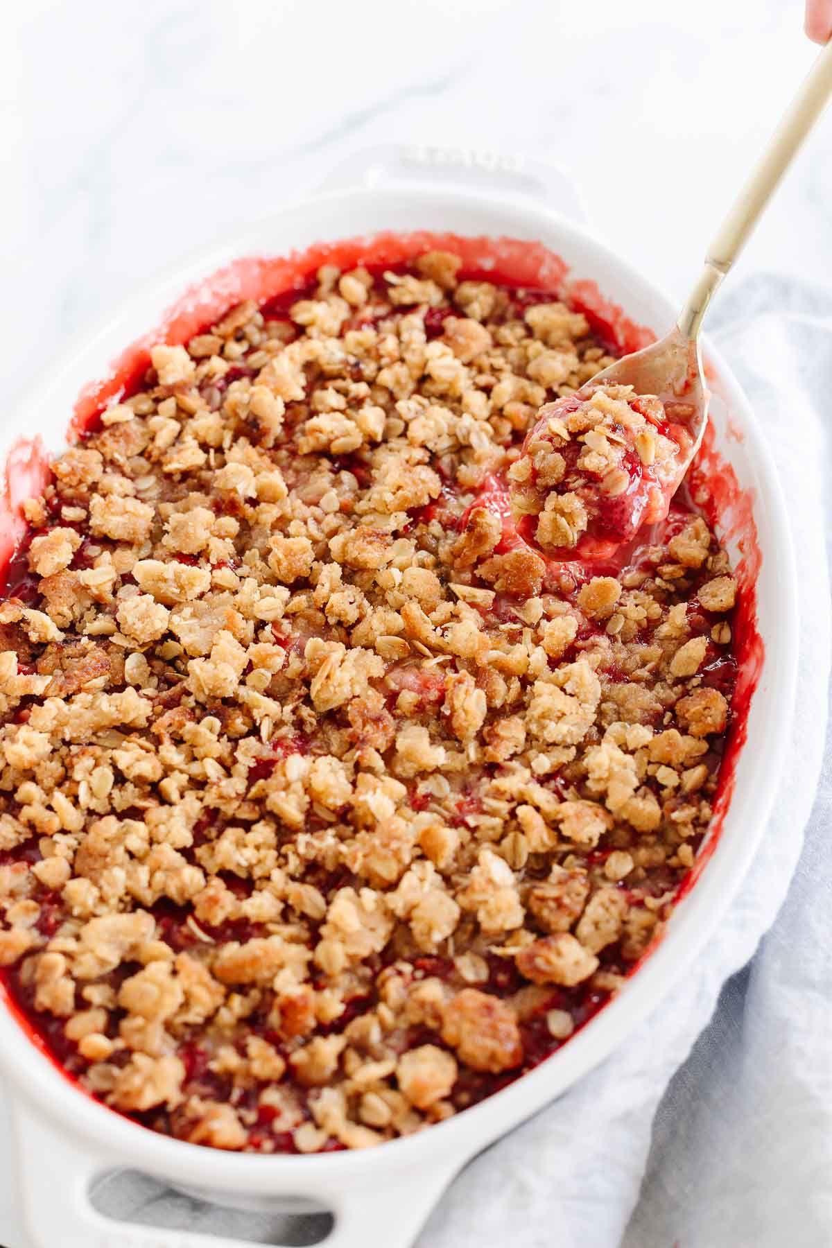 A strawberry crumble in a white oval baking dish
