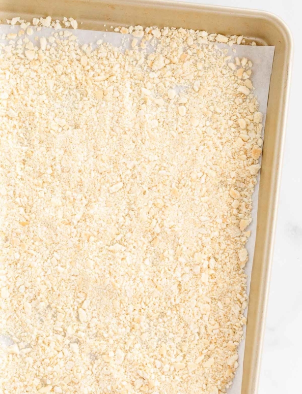 A panko substitute breadcrumb on a gold baking sheet lined with parchment paper