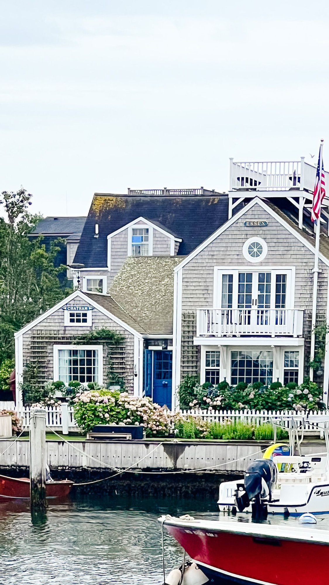 A shingled cottage on Nantucket, with faded hydrangeas and a blue door