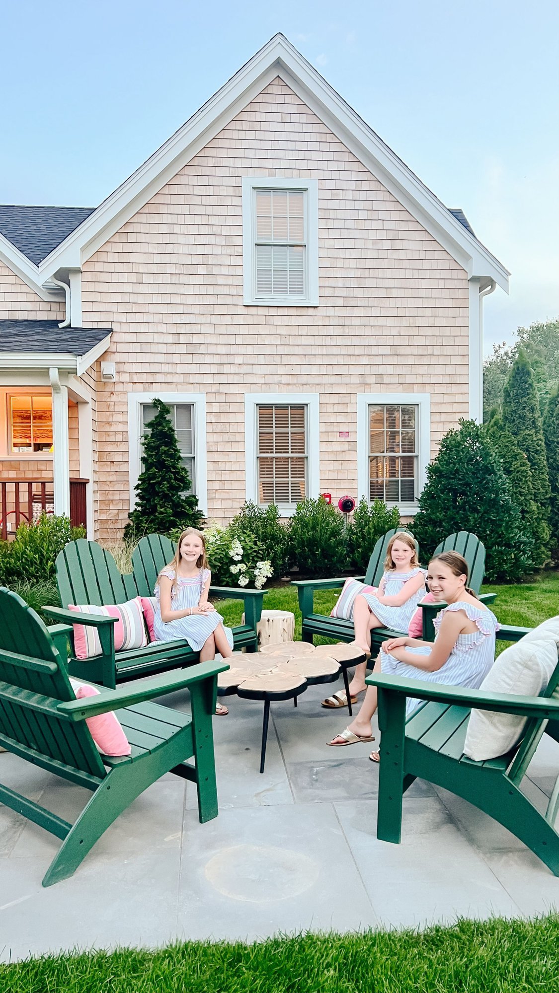 Three little girls on the green adirondack chairs outside of The Franklin Hotel, the best hotel for kids on Martha's Vineyard