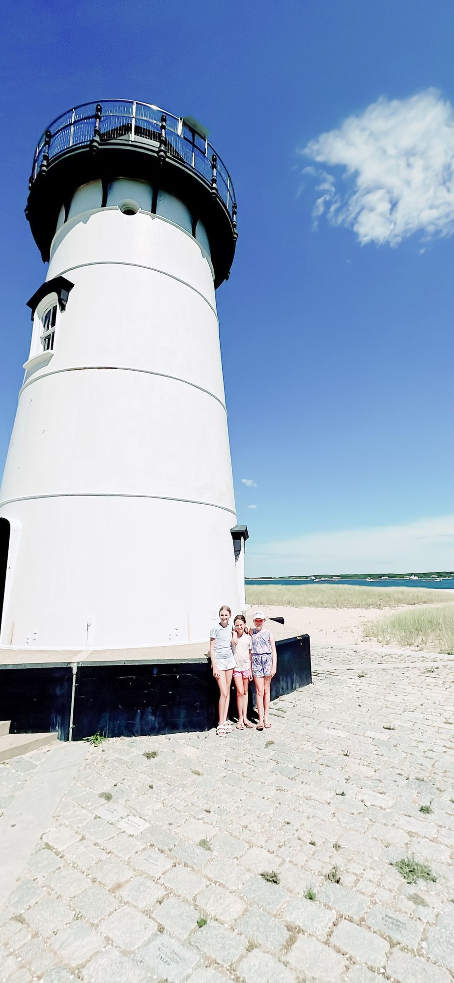 Three little girls standing in front of a lighthouse on Martha's Vineyard