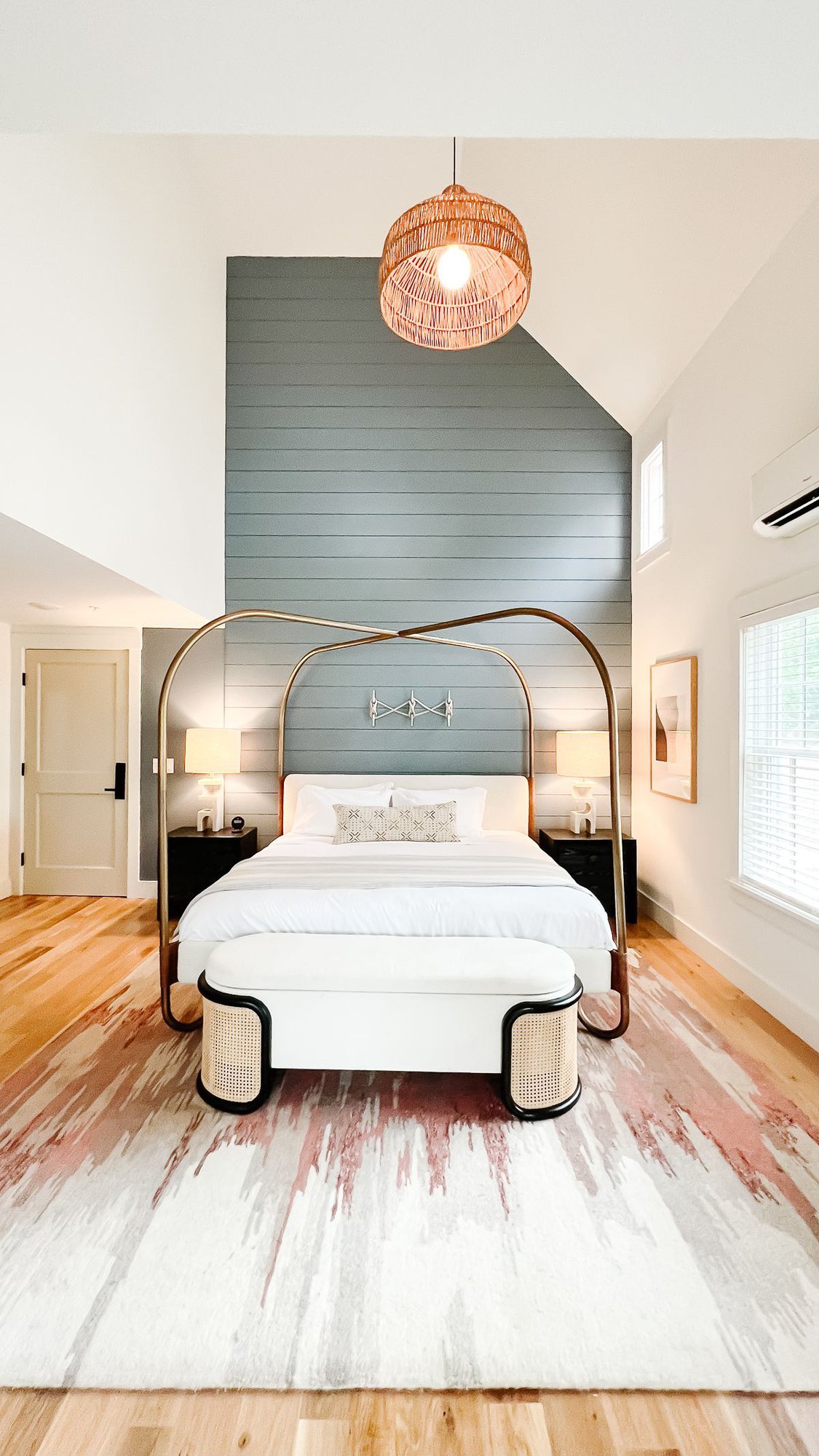 A bedroom with a dramatic canopy bed, a blue wall in the background, at a Martha's Vineyard hotel