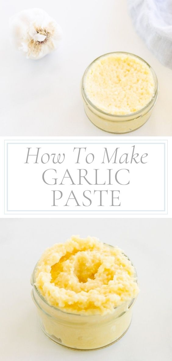 On a marble counter top there is a clear glass jar of garlic paste, a whole head of garlic, and a grey napkin.