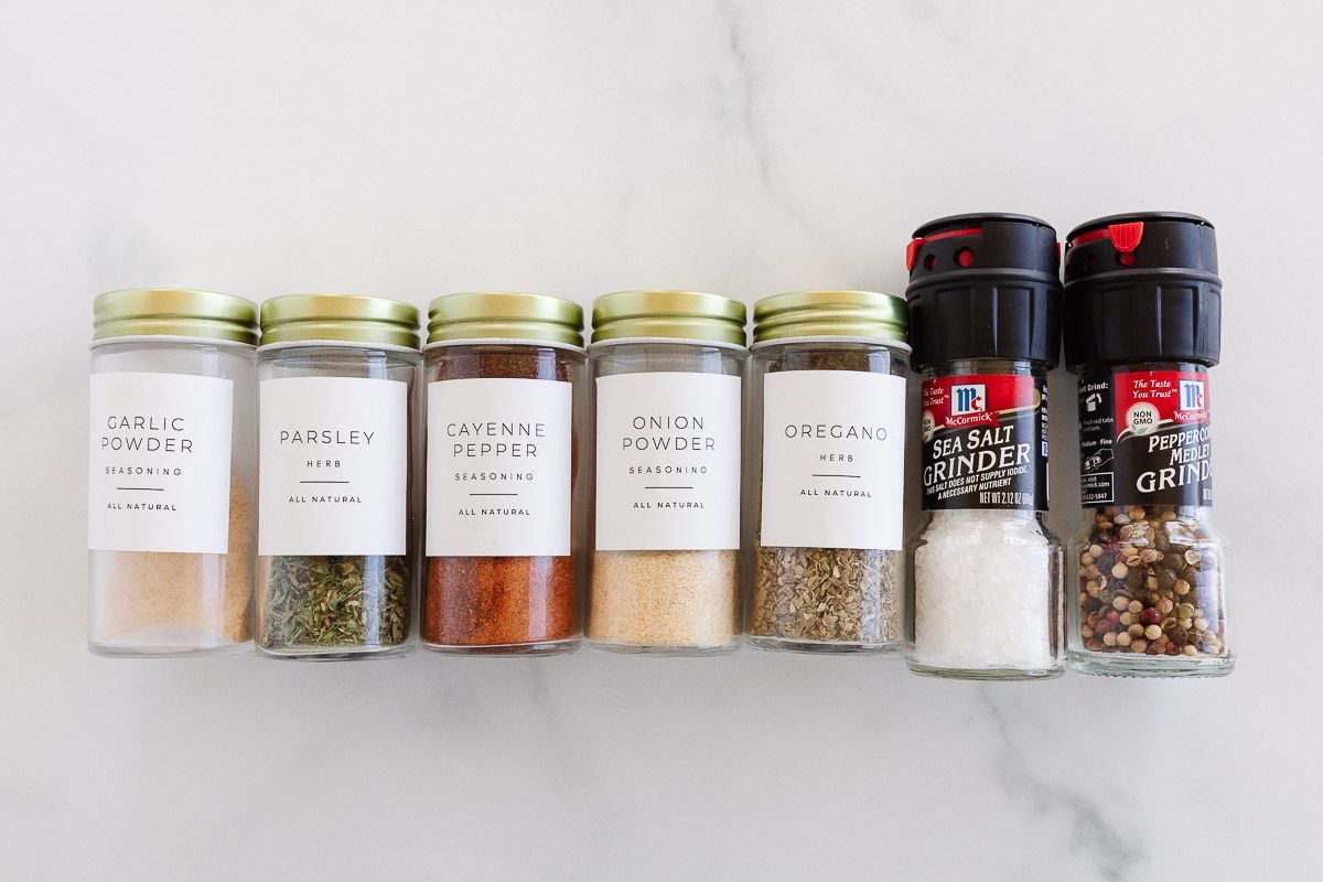 Ingredients for all purpose seasoning laid out on a marble surface.
