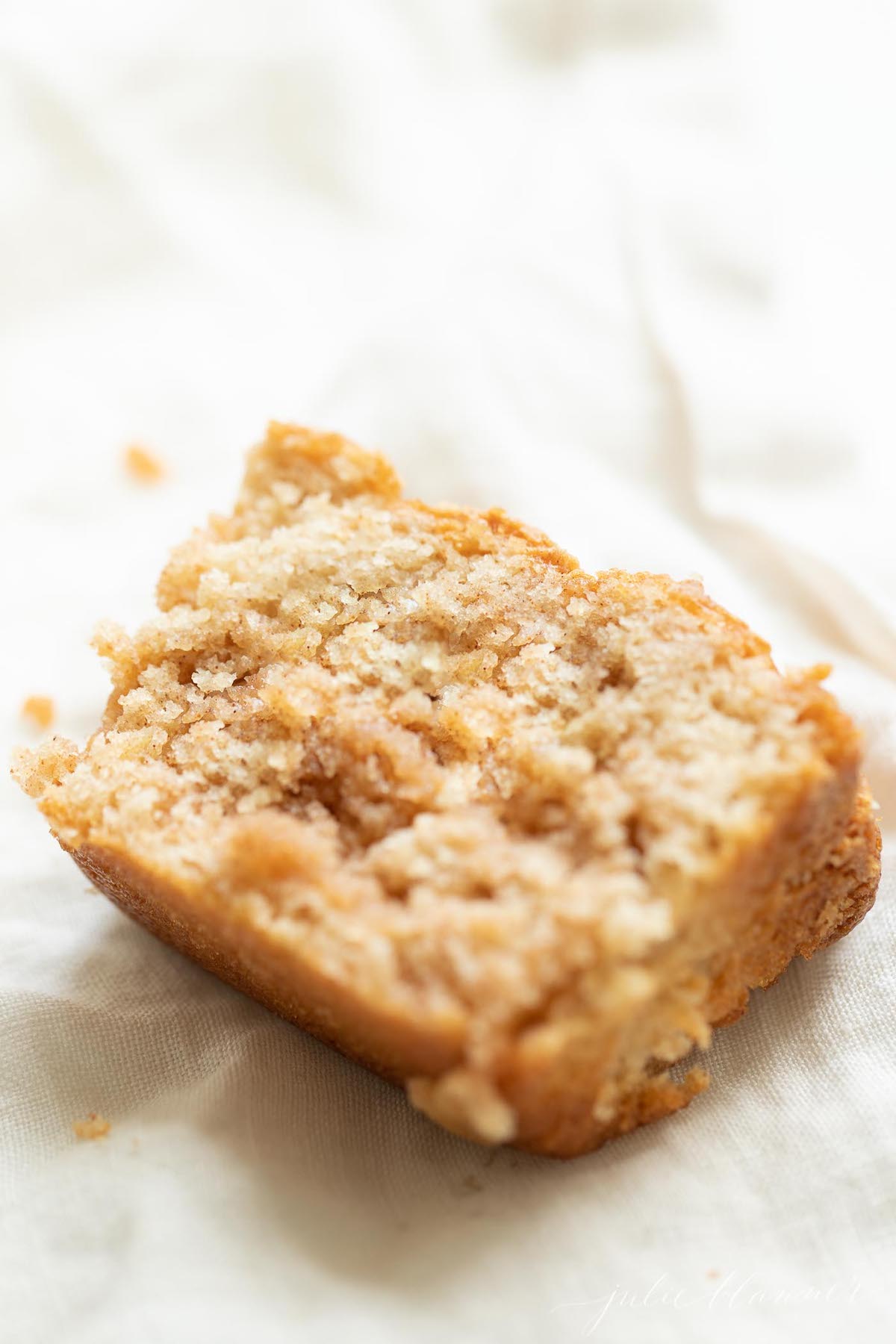 A slice of apple cinnamon bread on a white surface.