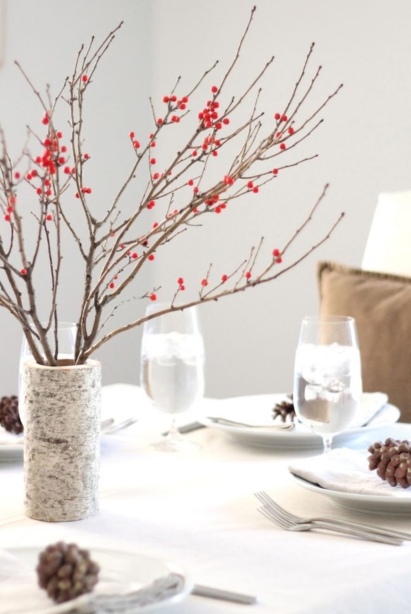 birch vase with red berries on neutral winter table setting