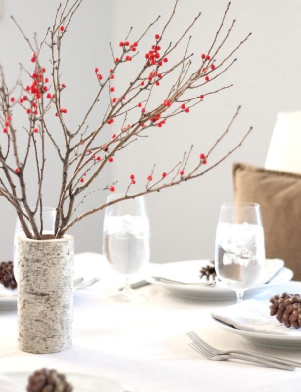 birch vase with red berries on neutral winter table setting