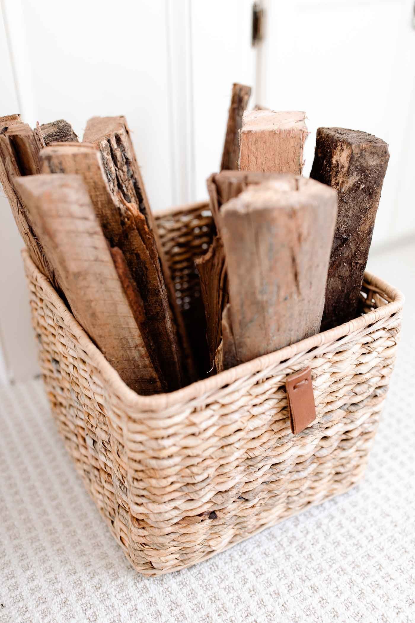 Firewood in a basket in front of a fireplace