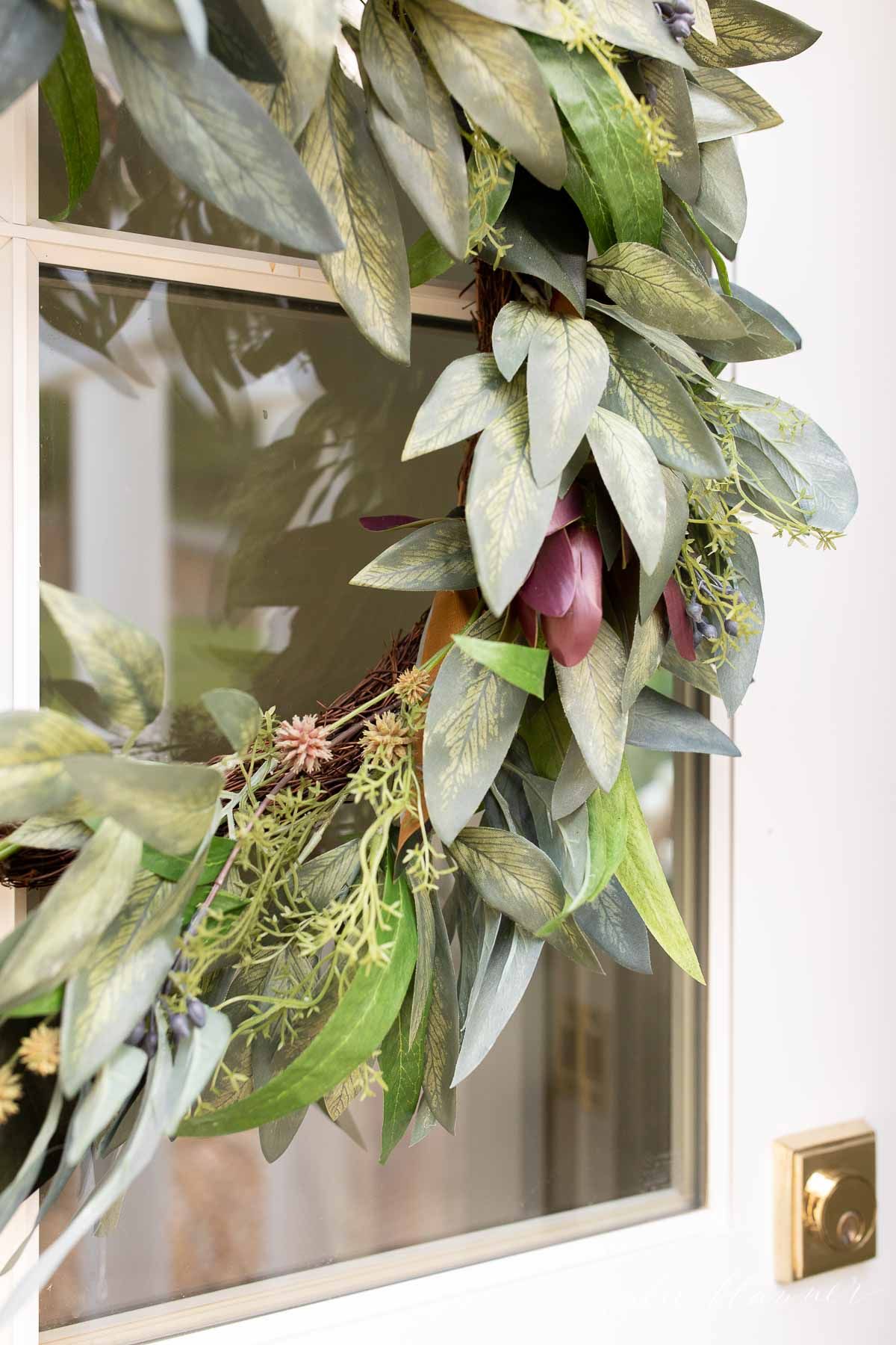 A fall wreath on a white front door