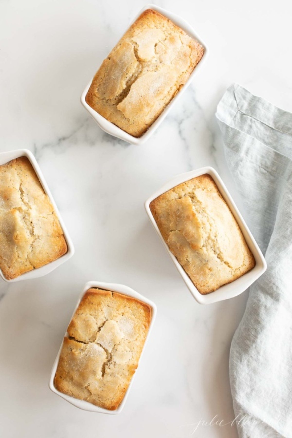 Small loaves of poppyseed bread on a marble countertop