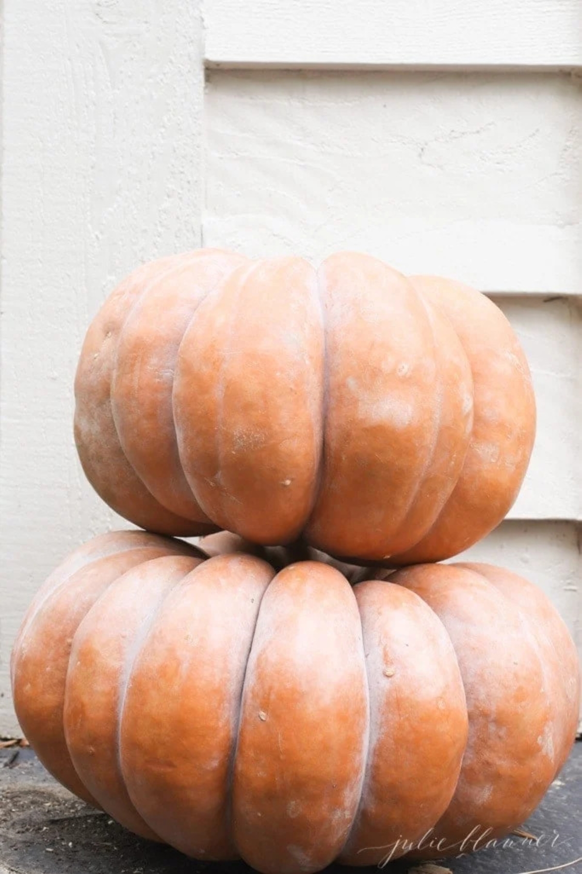 Two stacked heirloom pumpkins outside a home for a fall decor idea