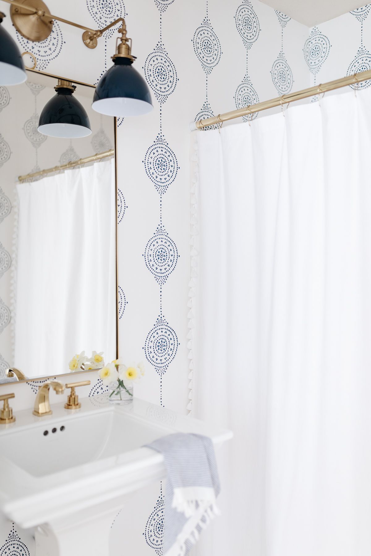 A bathroom with blue and white wallpaper and fixtures from Wayfair