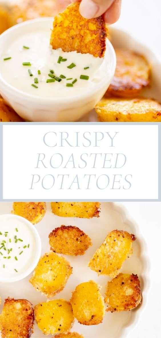 On a marble counter, there is a white platter of crispy roasted potatoes and a bowl of dip.