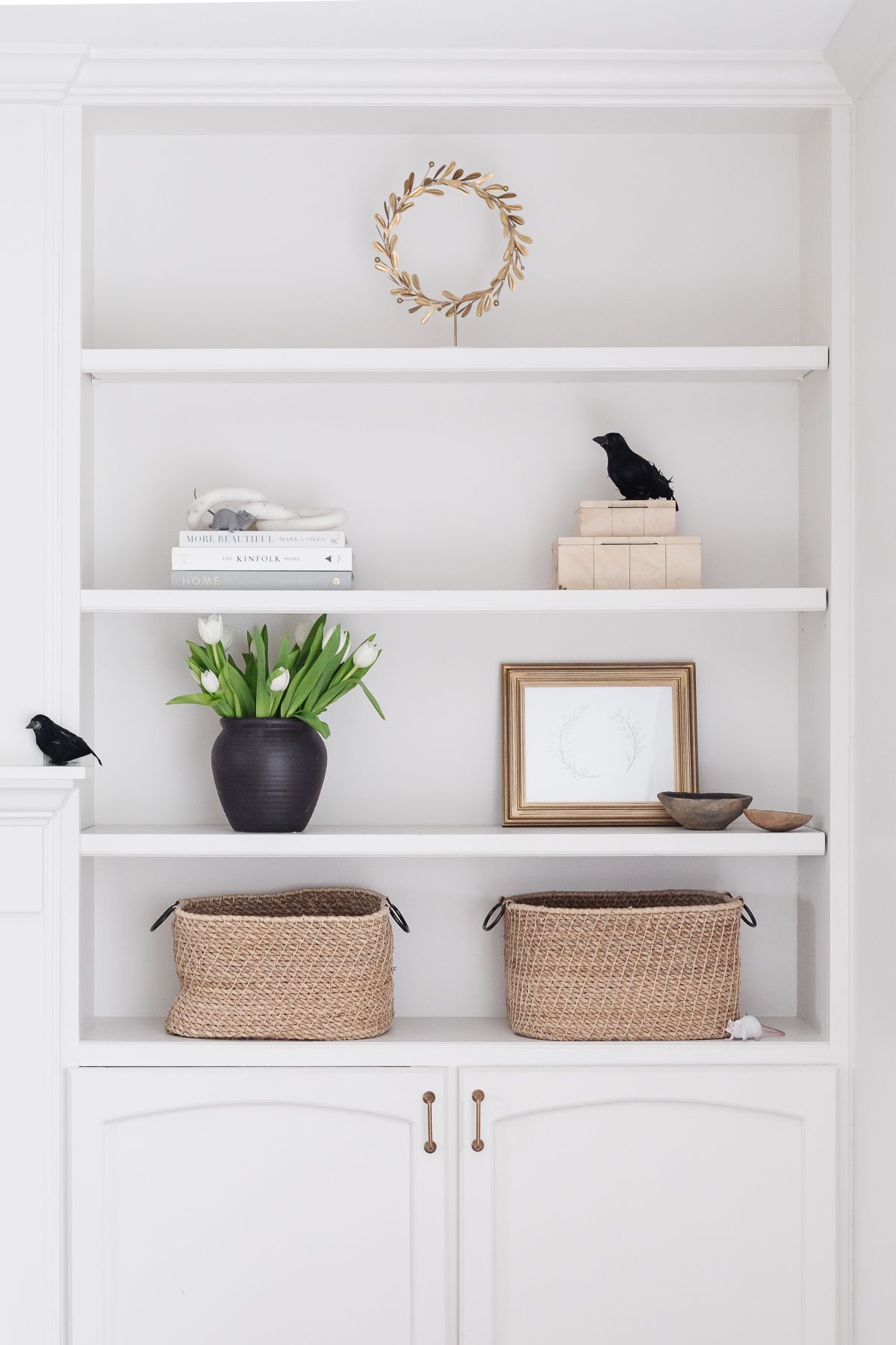 Black crows decorating a white built in bookshelf