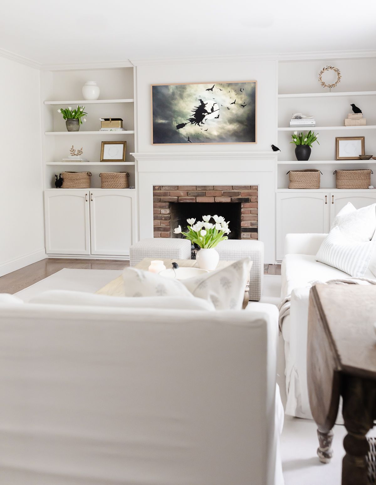 A white living room with a Frame TV that features Halloween witch artwork