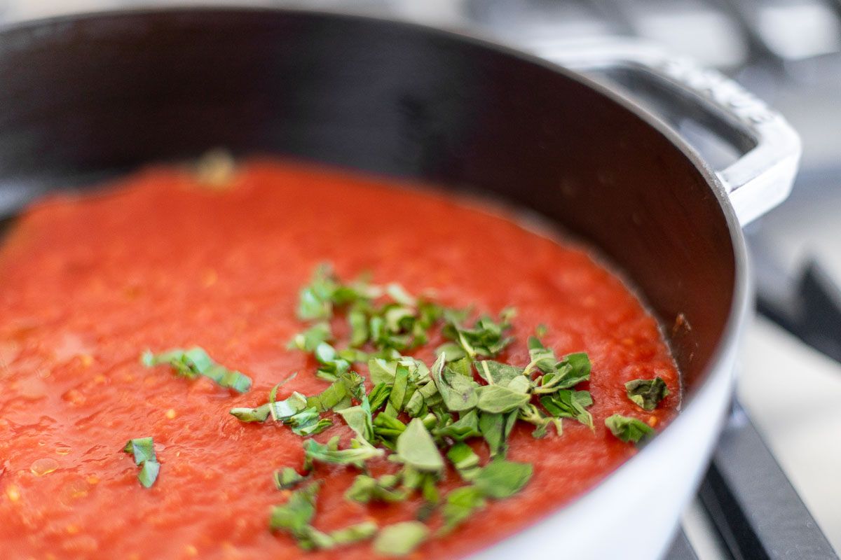 San Marzano tomato sauce in a cast iron pan, topped with chopped herbs.