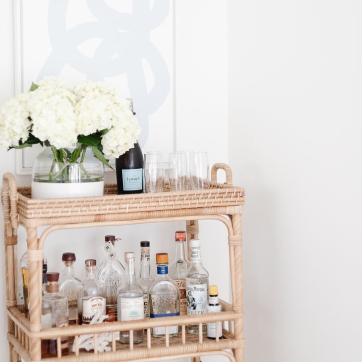 rattan bar cart with blue and white art above