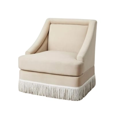 an upholstered armchair with fringe at the base