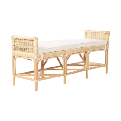 A rattan bench with a white seat cushion