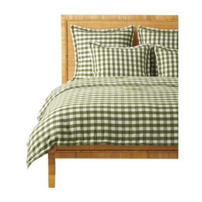 A rattan bed with a green and white gingham bedding set