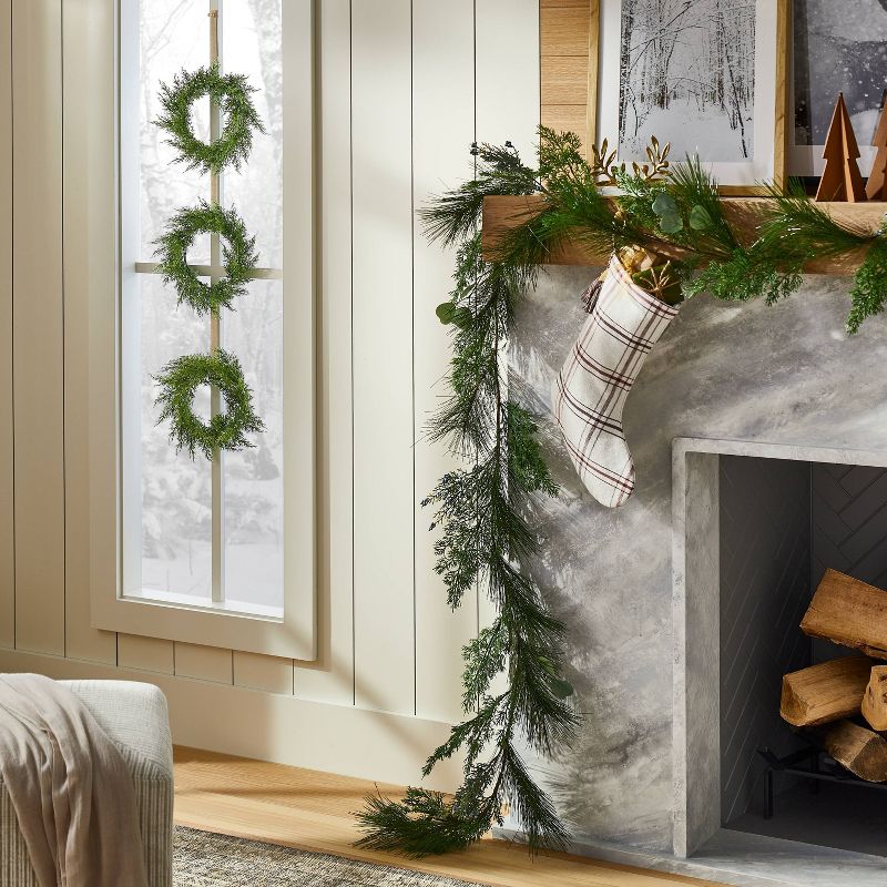 A Studio McGee for Target holiday set, with greenery on the door and mantel.