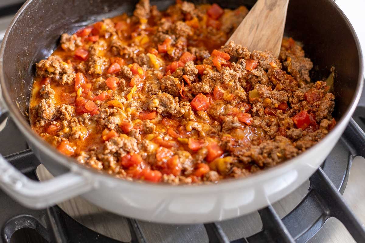 Taco meat for taco stuffed shells, in a gray pan on a stovetop