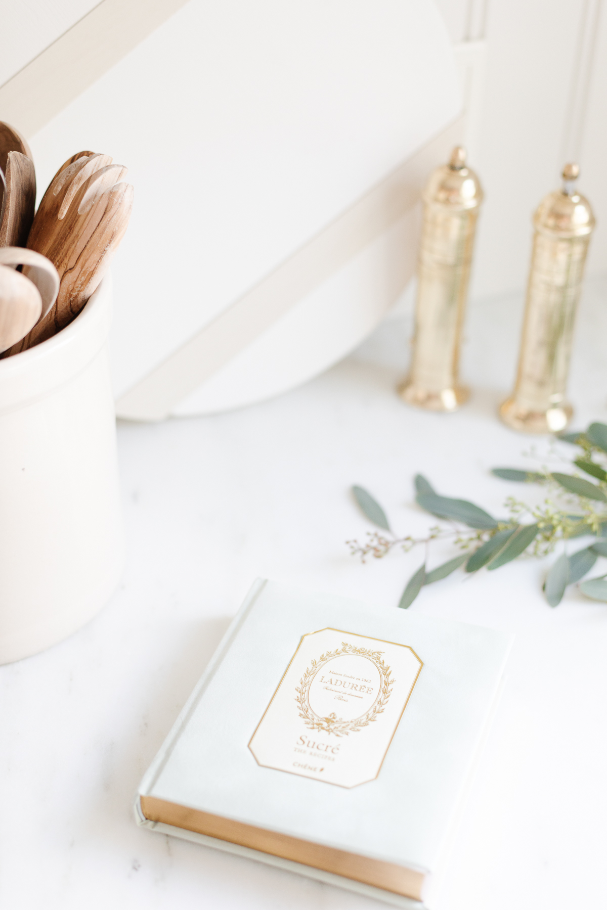 A kitchen with a white book and brass salt and pepper mills