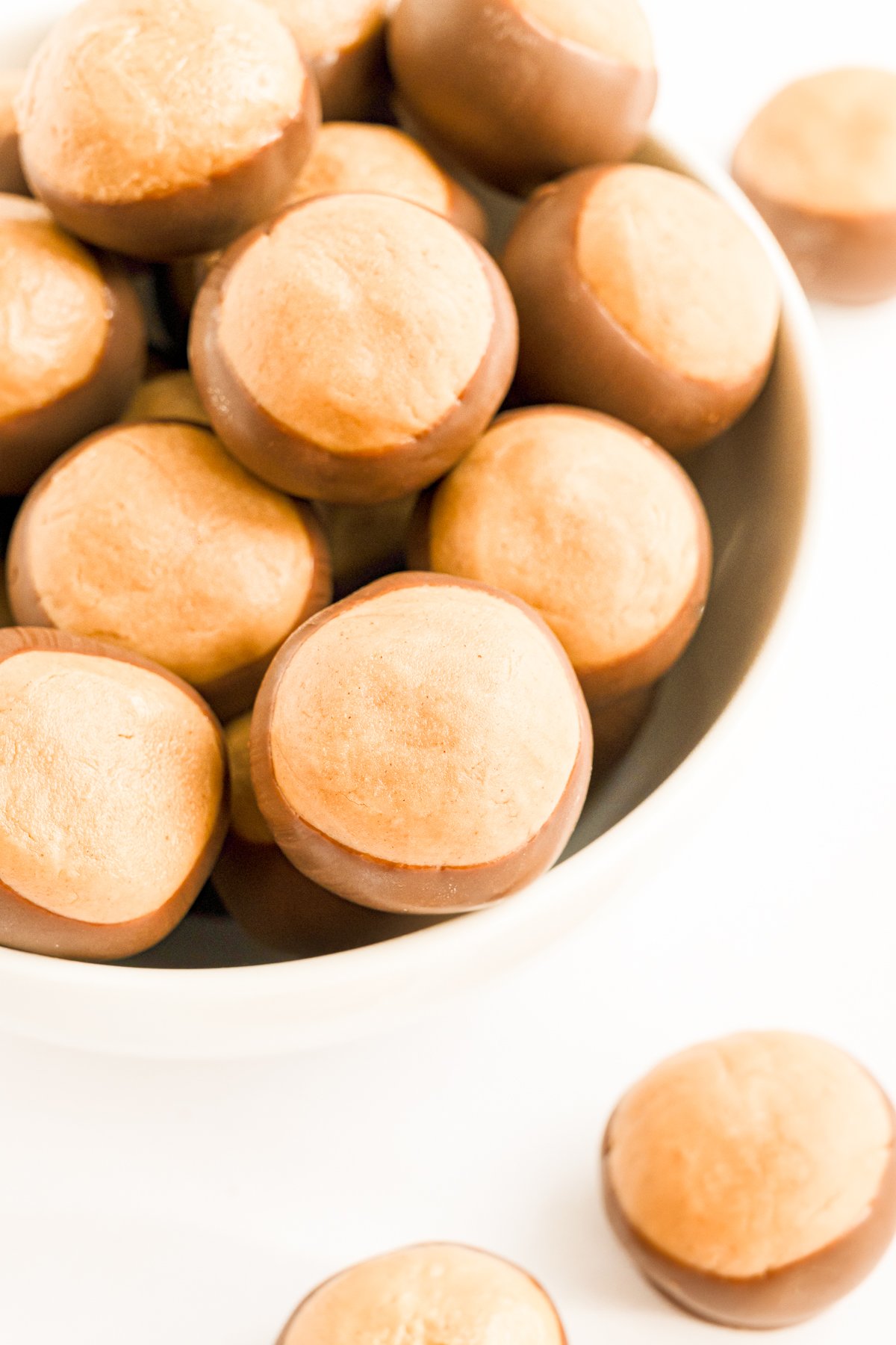 Buckeye recipe - Peanut butter balls in a bowl on a white surface.