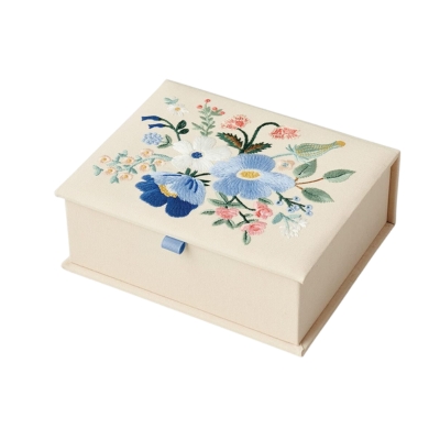 A white box adorned with delicate blue and white flowers, perfect for gift ideas.