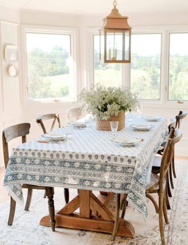 breakfast room with blue tablecloth flowers and brass pendant