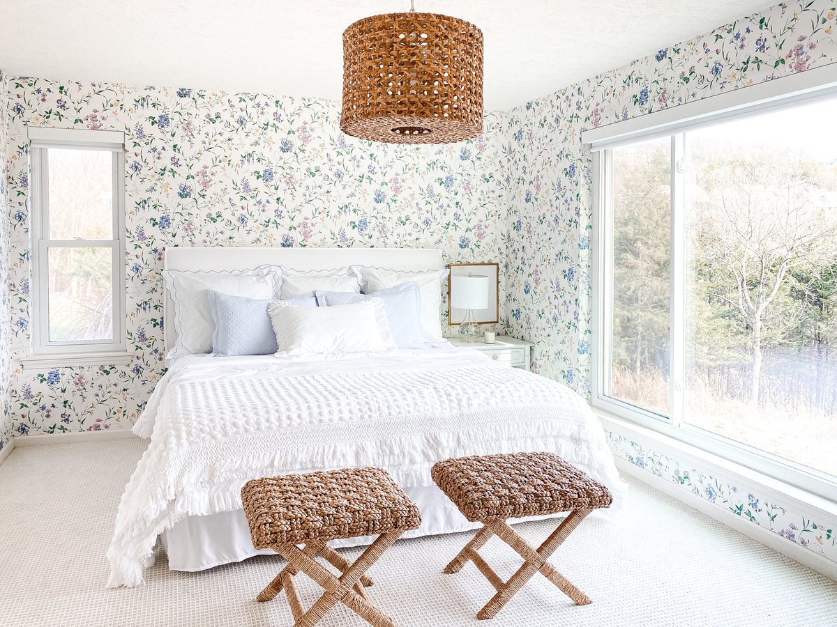 bedroom with floral wallpaper and rattan light and stools