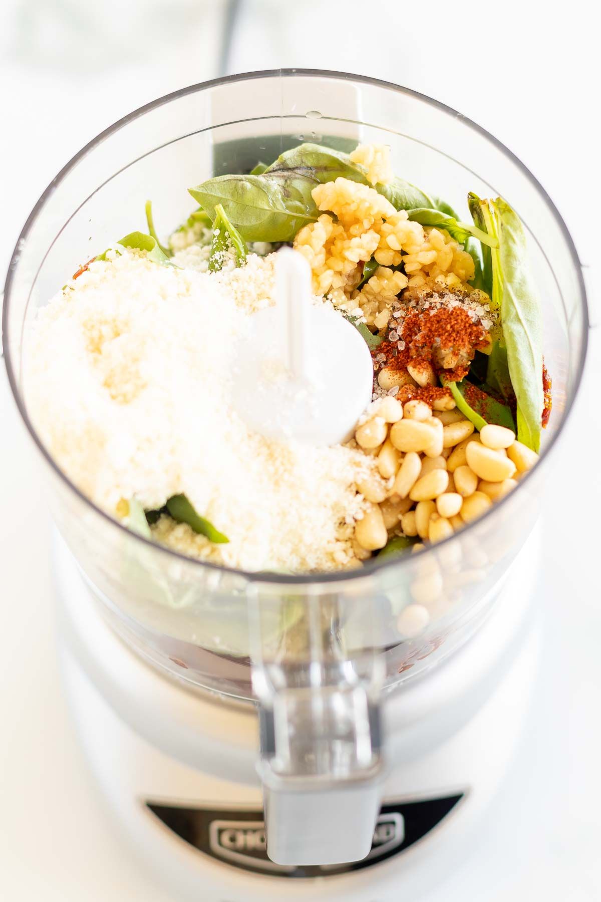 A food processor filled with ingredients for sun dried tomato pesto TeamJiX
