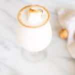 A snowball cocktail, adorned with whipped cream and walnuts, offers a delightful white drink experience.