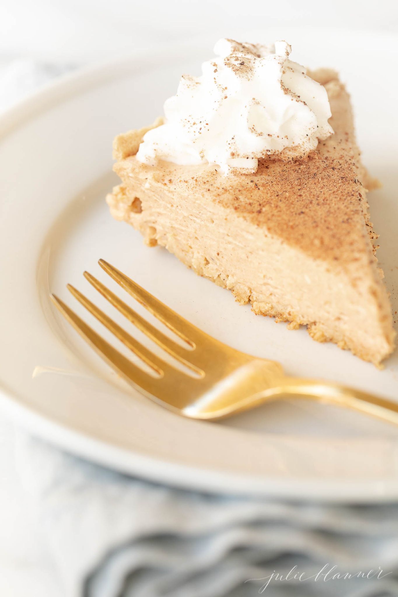 A slice of no bake pumpkin cheesecake on a white plate.