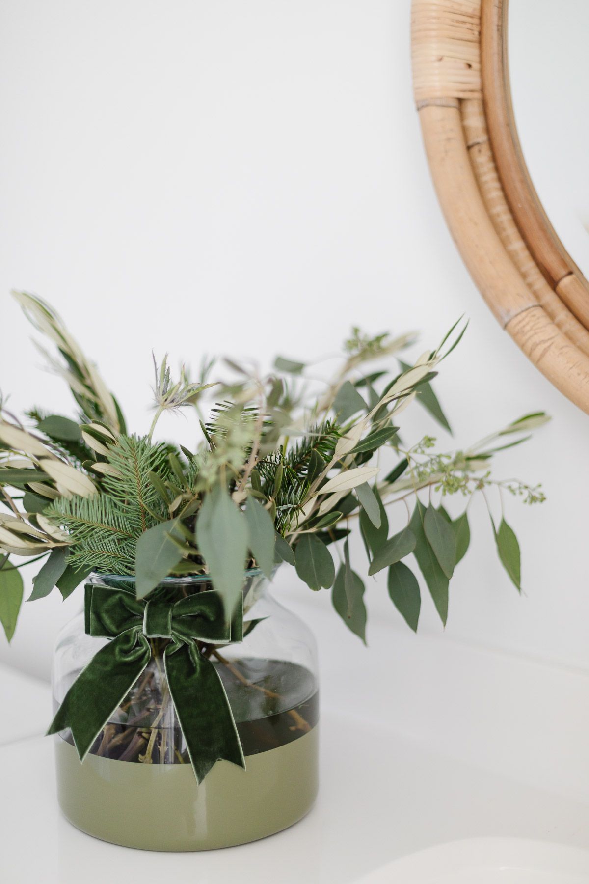 Fresh winter greenery in a green dipped vase