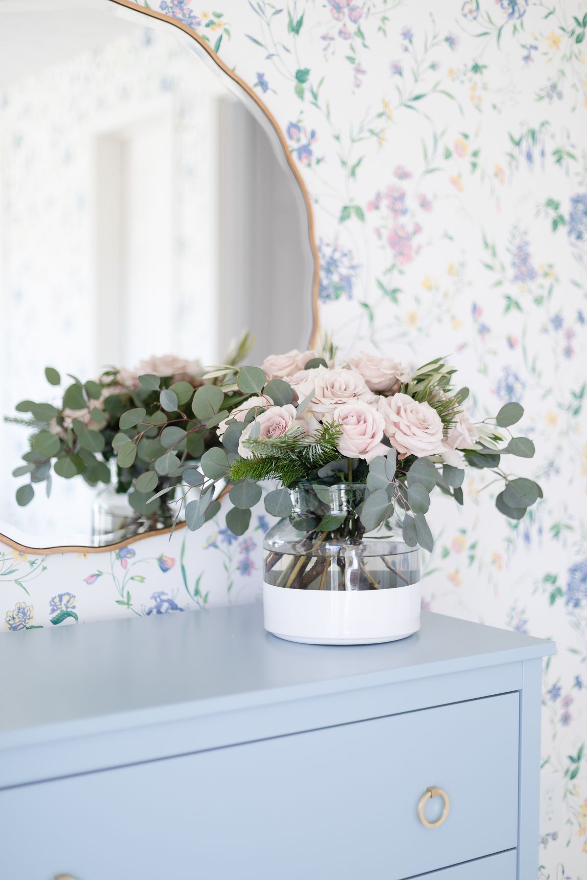 A wintry pink and green arrangement for a coastal Christmas look in a floral bedroom.