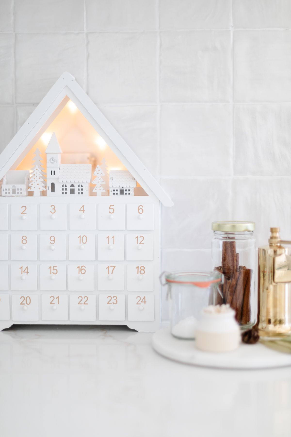 A white wood Advent calendar in a white kitchen.