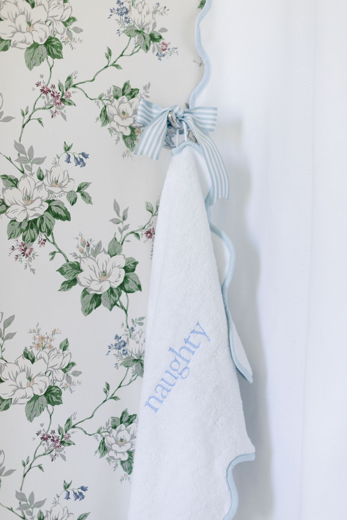 A blue and white towel that is embroidered with the word 