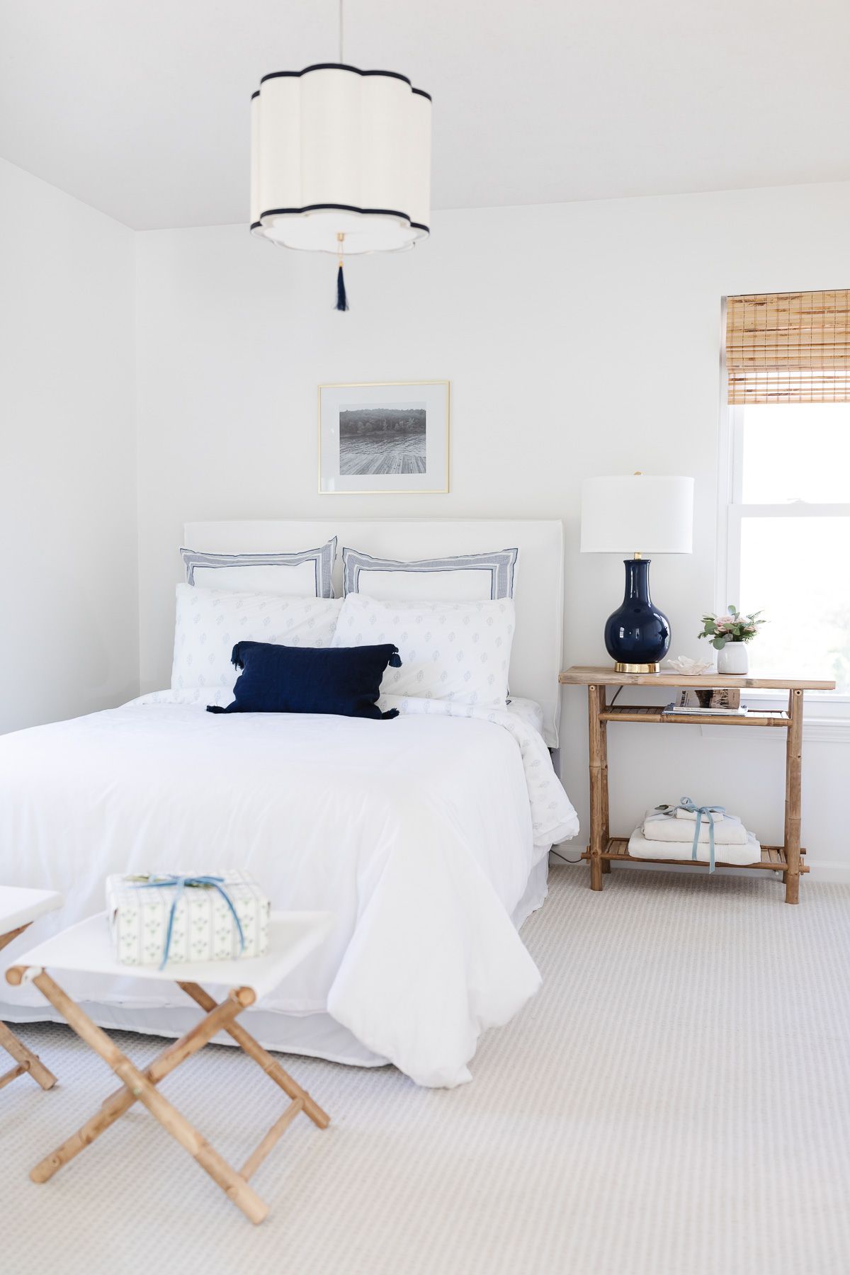 A coastal Christmas guest bedroom with white bedding and white walls.