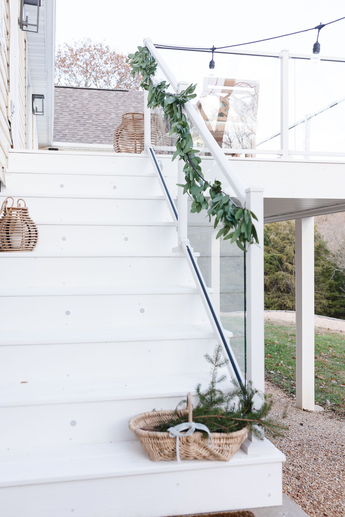 A white deck decorated with a greenery garland for a coastal Christmas look.