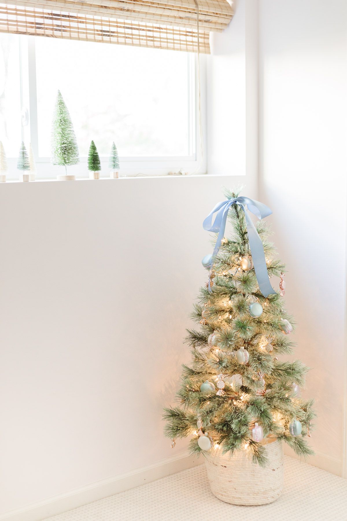 A small coastal Christmas tree in a pale pink bedroom