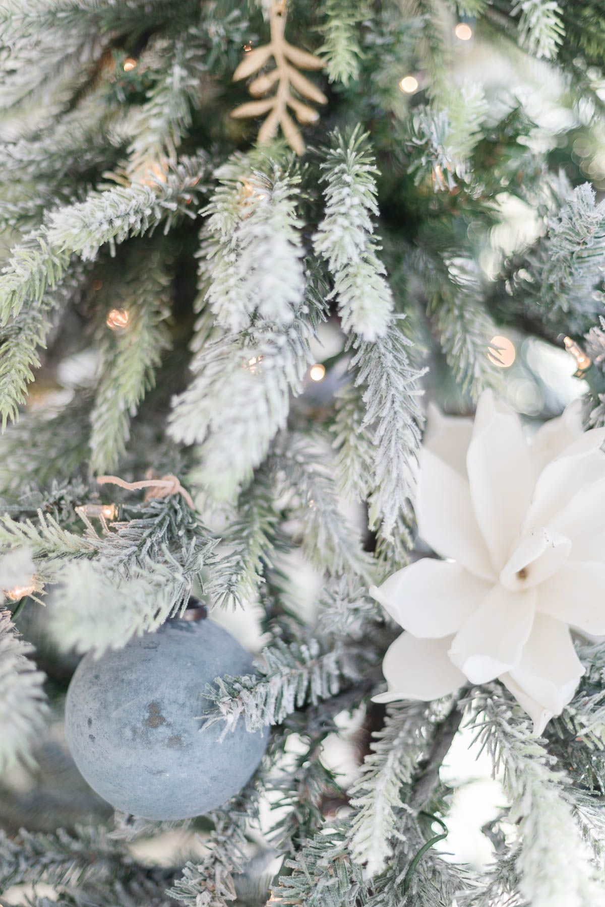 White flowers and brass ornaments on a coastal Christmas tree