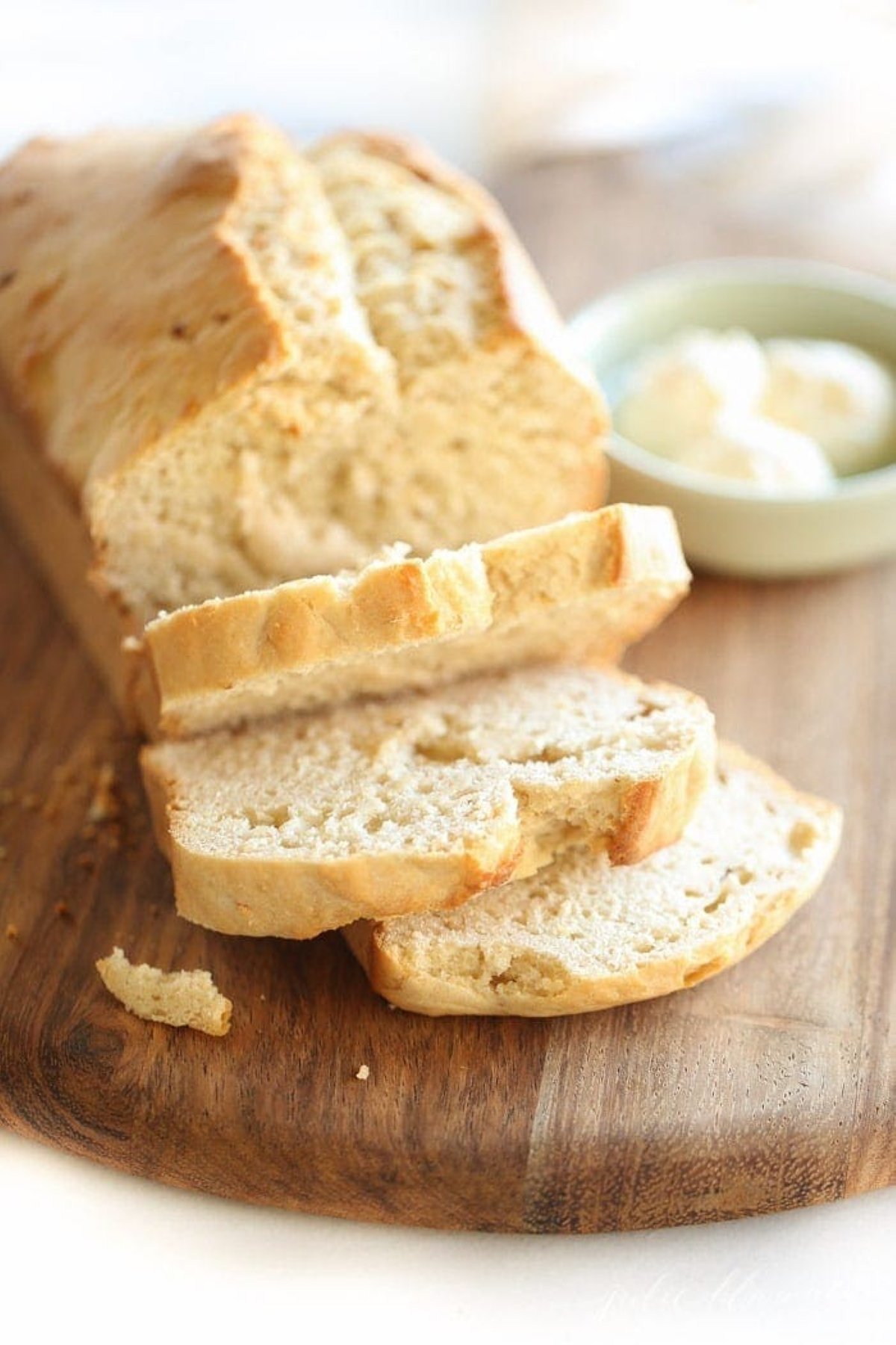 honey beer bread, sliced with a bowl of butter nearby