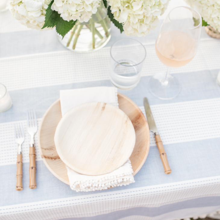 table setting with bamboo plates and flatware and hydrangea