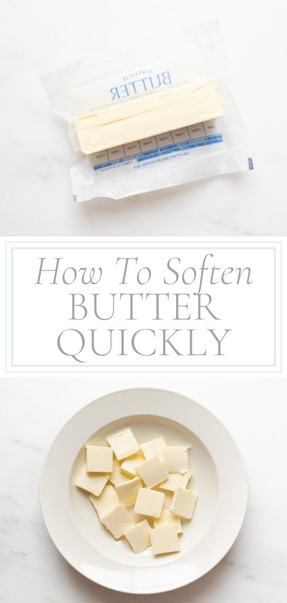 On a marble counter, there is a stick of butter in its original wrapper and a round white plate of cubed butter.