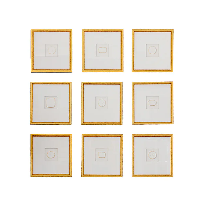 Ten gold-framed square artworks, reminiscent of delicate intaglios, are arranged in a 2-row by 5-column grid, each featuring a minimal circular or square white shape on a white background.