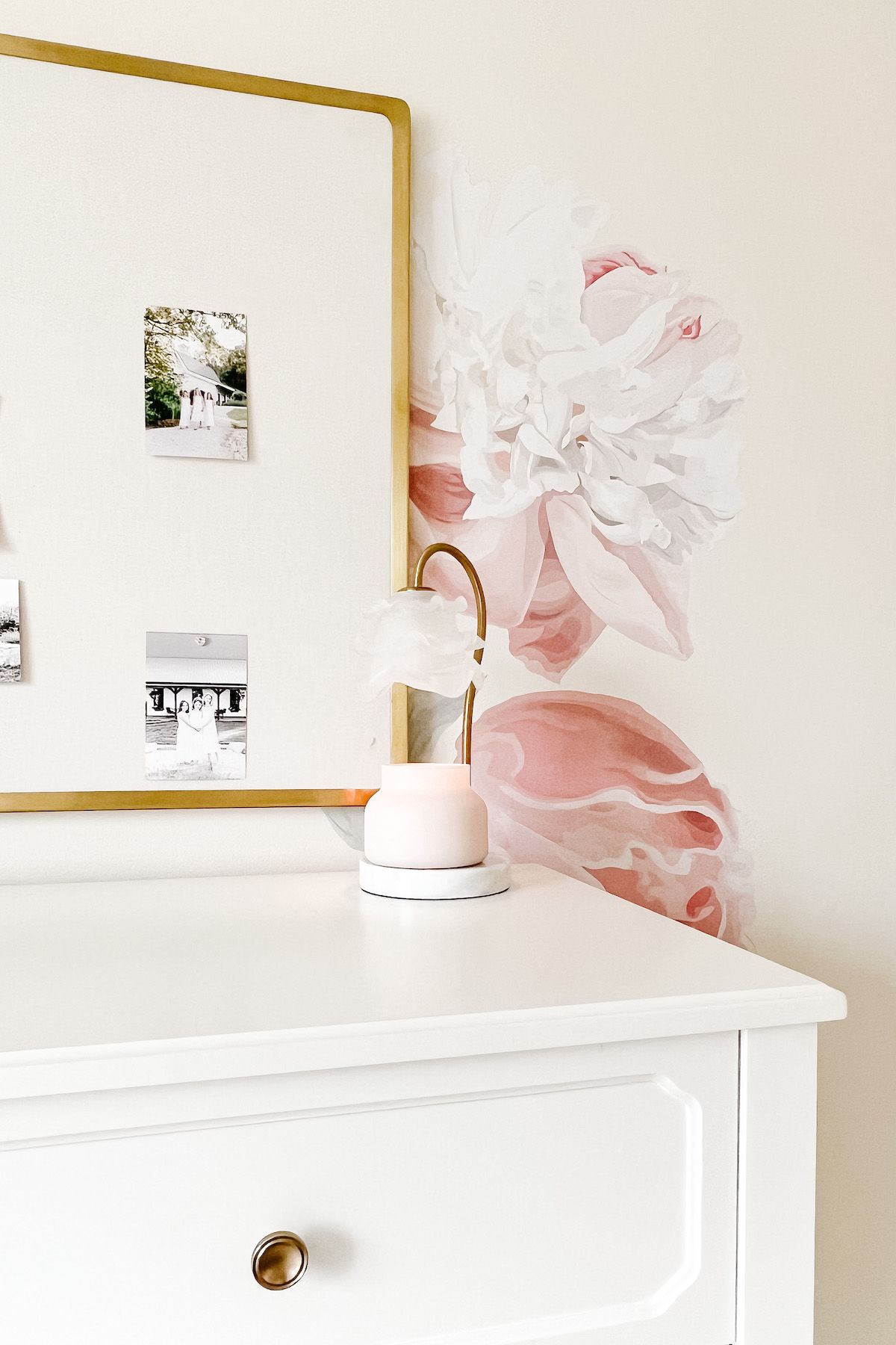 A girl's room with white furniture, a pink floral wallpaper, and a candle warmer Amazon gadget on the dresser. 