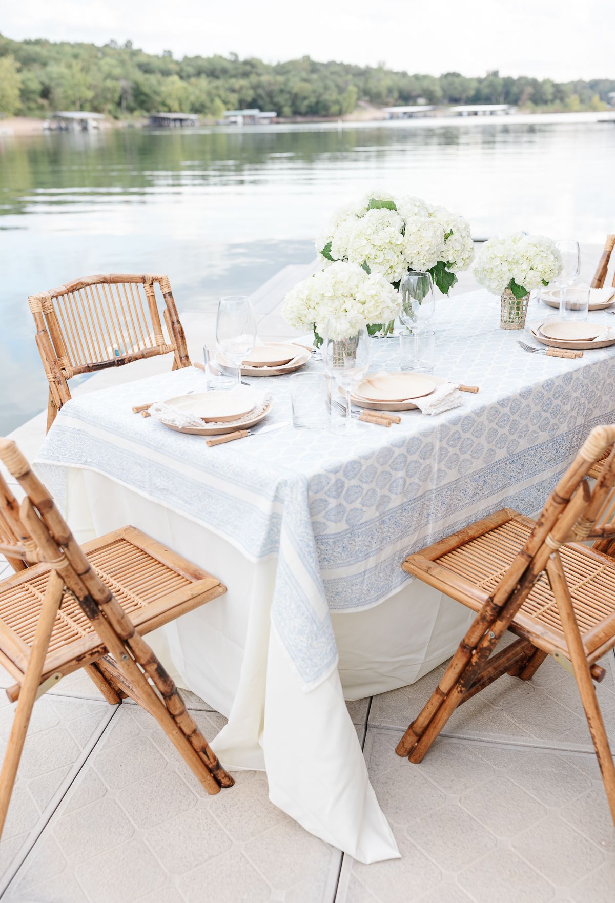 An outdoor dining table with a block print tablecloth and bamboo folding chairs. 