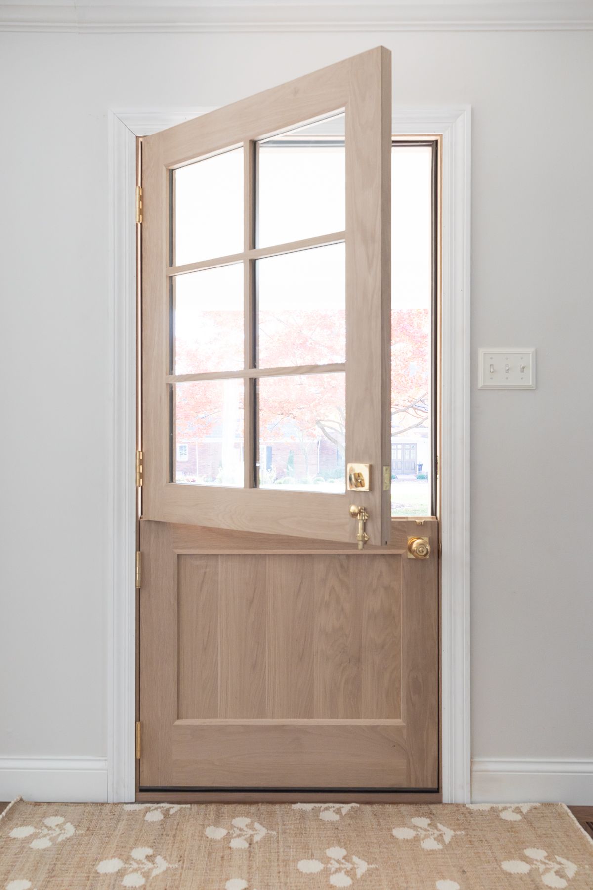 A wooden dutch door with a block print jute rug in front. 